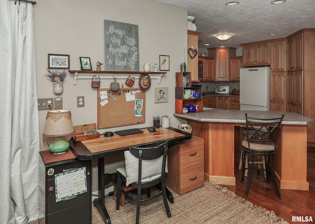 office space featuring a toaster, wood finished floors, and a textured ceiling