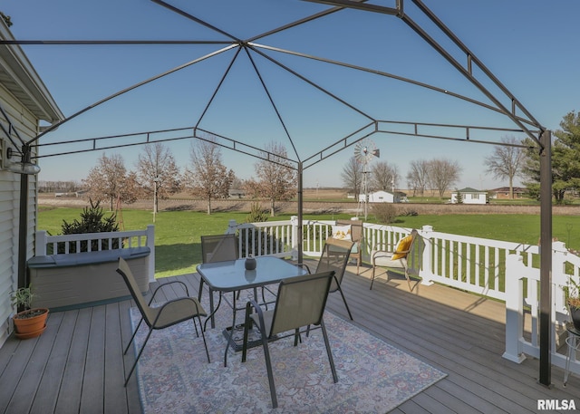 wooden deck featuring outdoor dining area and a lawn