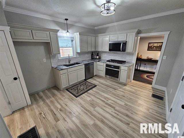 306 Walker St, Ursa, IL 62376 - kitchen featuring light wood-type flooring, ornamental molding, visible vents, appliances with stainless steel finishes, and a sink