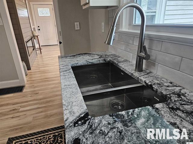 306 Walker St, Ursa, IL 62376 - details with tasteful backsplash, light wood-type flooring, stone counters, white cabinets, and a sink