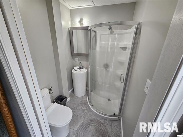 306 Walker St, Ursa, IL 62376 - bathroom with a shower stall, tile patterned flooring, and toilet