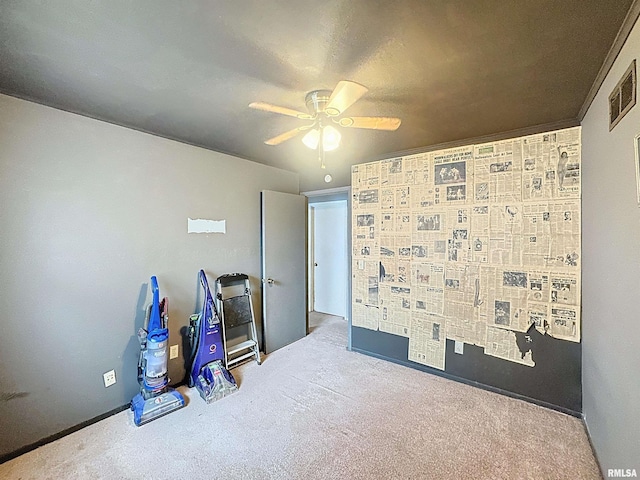 empty room with visible vents, carpet floors, and ceiling fan