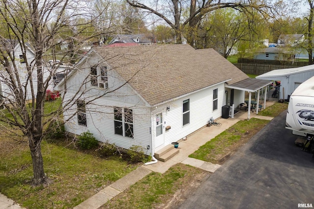 view of front of house featuring entry steps, a shingled roof, and fence