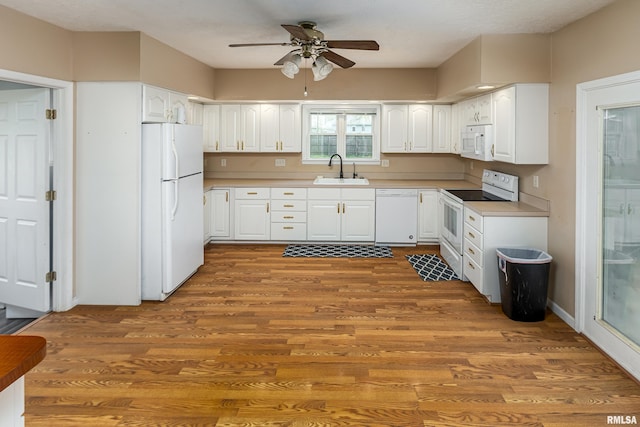 kitchen featuring ceiling fan, white appliances, white cabinetry, wood finished floors, and a sink