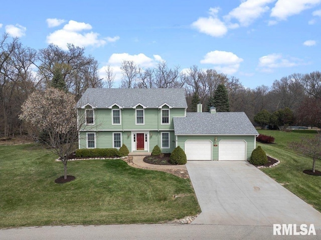 colonial house featuring concrete driveway, an attached garage, and a front yard