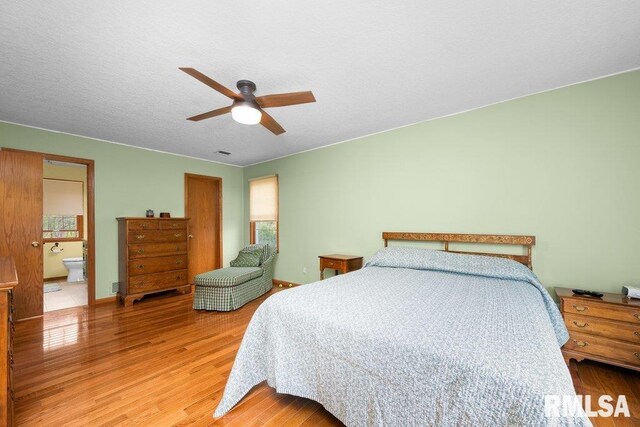 bedroom featuring ceiling fan, light wood finished floors, connected bathroom, and visible vents