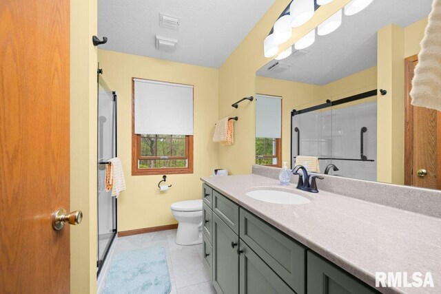 bathroom with vanity, tile patterned floors, baseboards, visible vents, and a stall shower