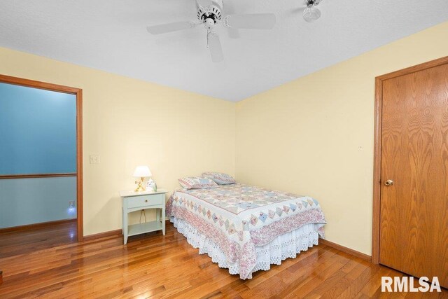 bedroom featuring baseboards, a ceiling fan, and wood finished floors