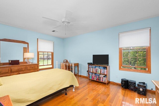 bedroom featuring visible vents, a ceiling fan, light wood-style floors, and baseboards