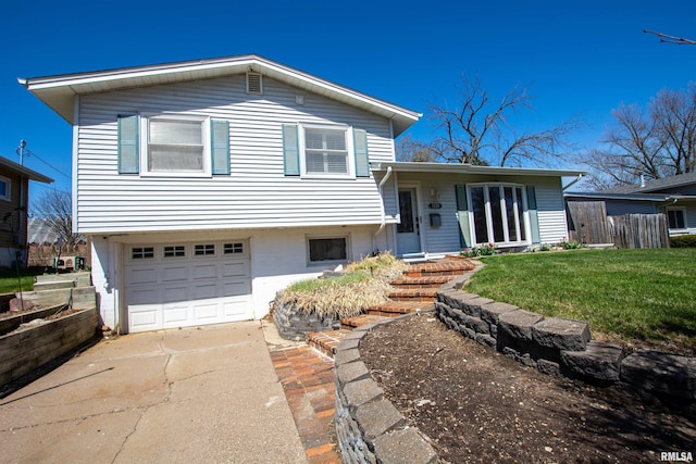 split level home featuring a front yard, an attached garage, fence, and driveway