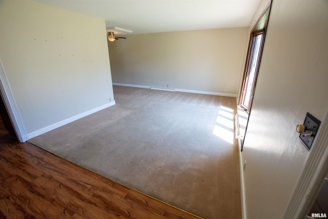 unfurnished room featuring visible vents, baseboards, wood finished floors, and ceiling fan