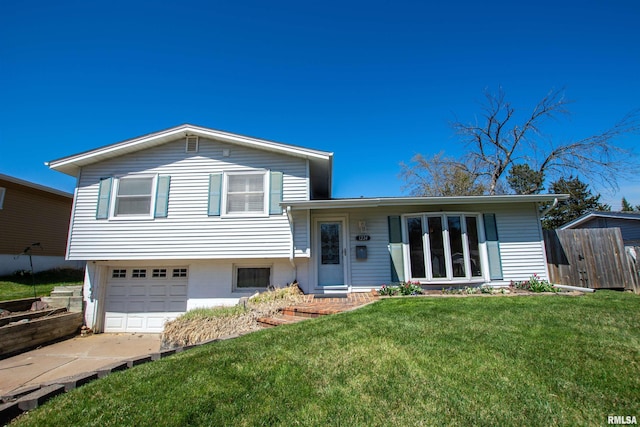 split level home featuring a front lawn, fence, a garage, and concrete driveway