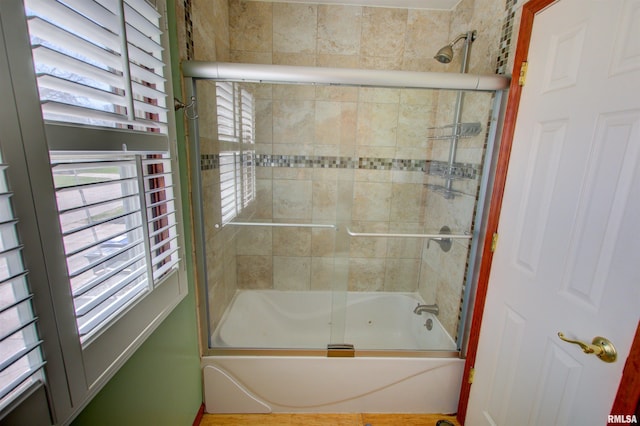 bathroom featuring enclosed tub / shower combo and a wealth of natural light