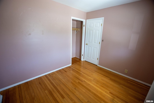 unfurnished bedroom featuring light wood-style floors, a closet, and baseboards