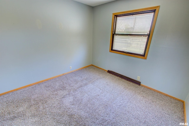 carpeted spare room featuring baseboards