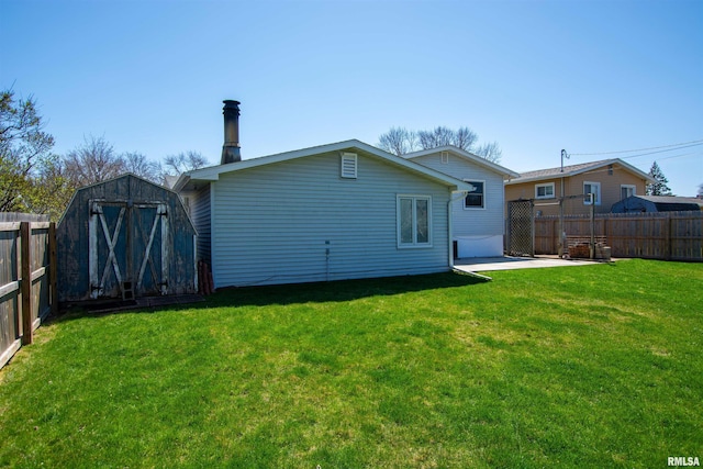 rear view of house with a fenced backyard, a shed, an outdoor structure, and a lawn