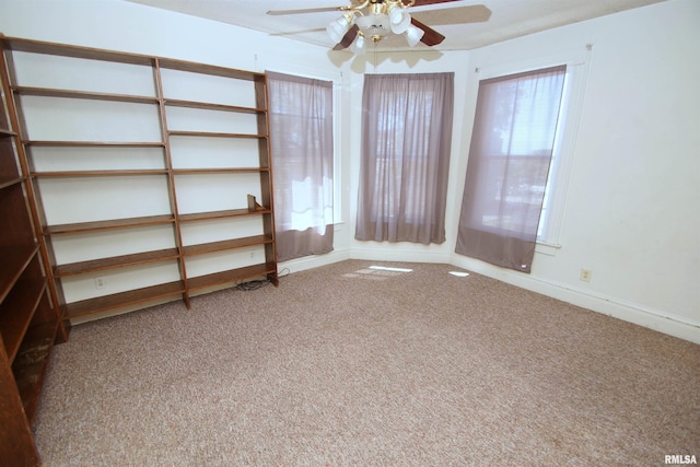empty room with ceiling fan, baseboards, carpet, and plenty of natural light