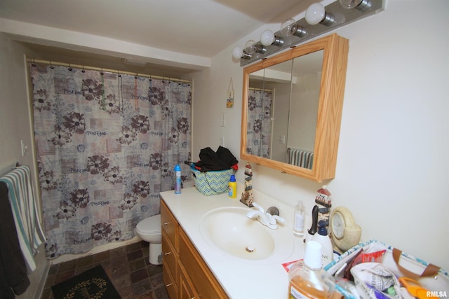 full bath featuring a shower with shower curtain, stone finish floor, vanity, and toilet