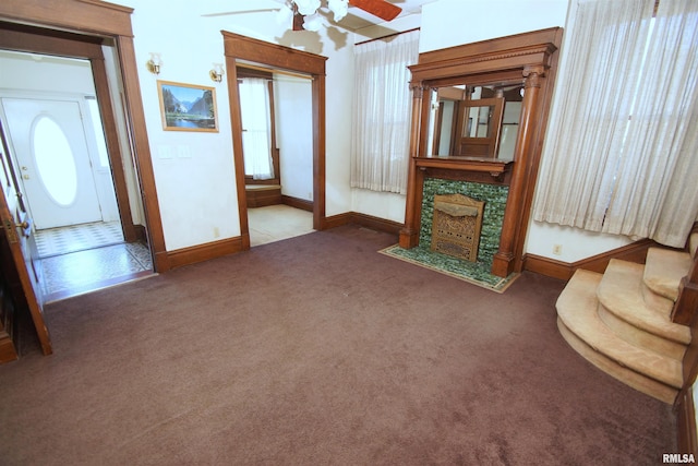 living area with ceiling fan, carpet flooring, baseboards, and a fireplace