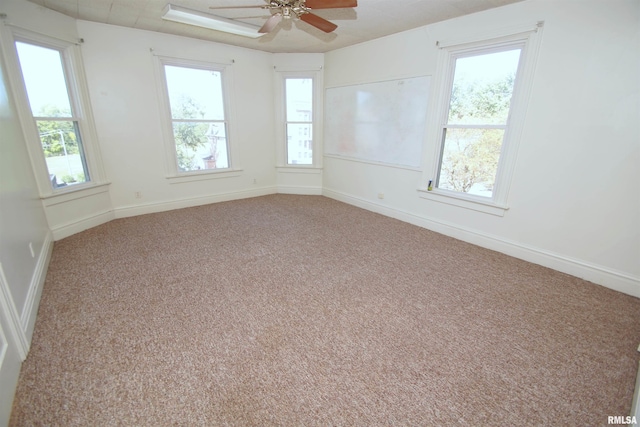carpeted empty room featuring baseboards and ceiling fan