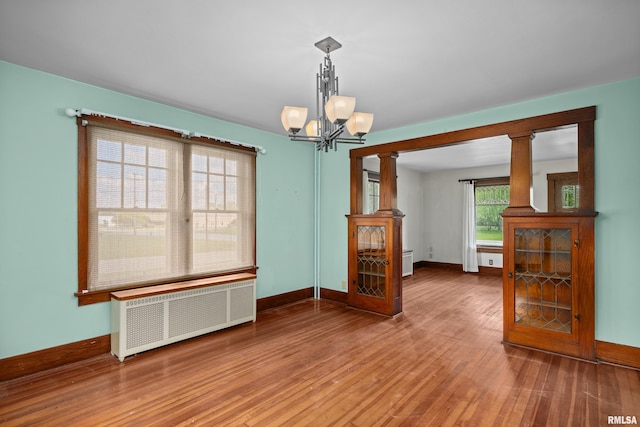 408 E Henry St, Atkinson, IL 61235 - unfurnished room with radiator, baseboards, a chandelier, and wood finished floors