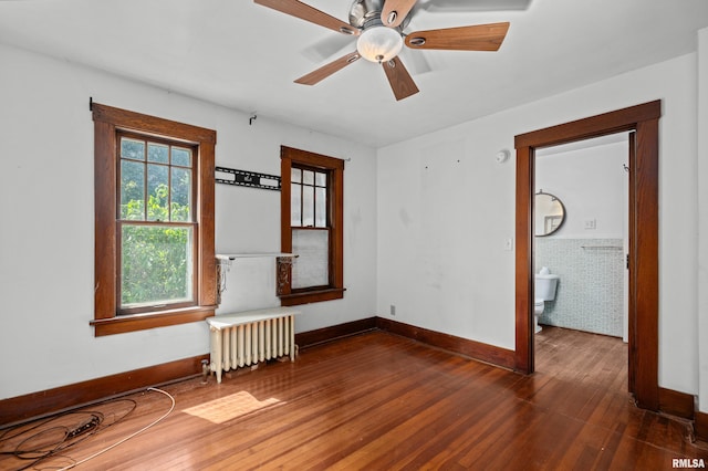 408 E Henry St, Atkinson, IL 61235 - unfurnished room with radiator, hardwood / wood-style floors, baseboards, and a ceiling fan