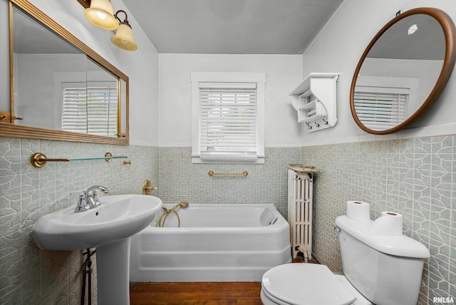 408 E Henry St, Atkinson, IL 61235 - bathroom with wainscoting, toilet, a garden tub, tile walls, and wood finished floors