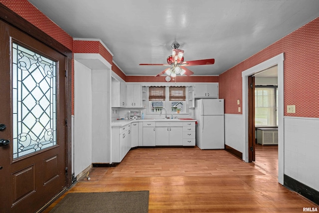 408 E Henry St, Atkinson, IL 61235 - kitchen with freestanding refrigerator, ceiling fan, a wainscoted wall, light countertops, and white cabinets