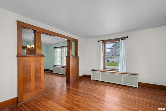 408 E Henry St, Atkinson, IL 61235 - spare room with radiator heating unit, baseboards, wood finished floors, and ornate columns