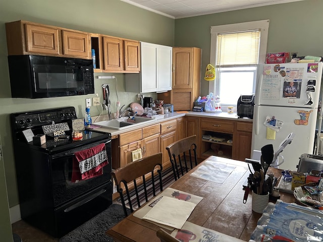 kitchen featuring light countertops, crown molding, a sink, and black appliances