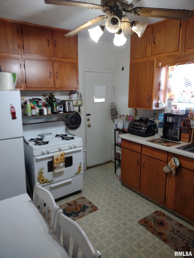 kitchen featuring gas range gas stove, brown cabinetry, a ceiling fan, light countertops, and light floors