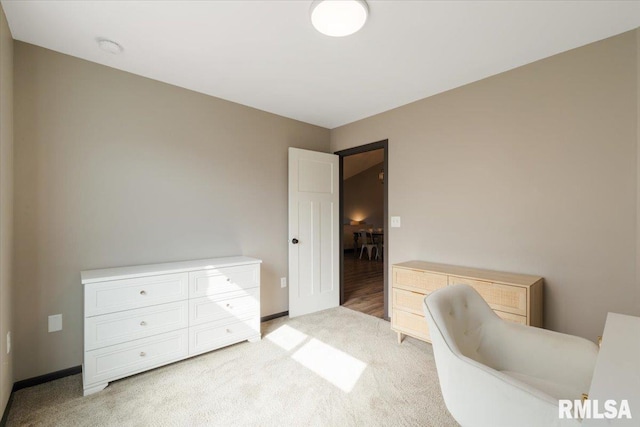 living area featuring light carpet and baseboards