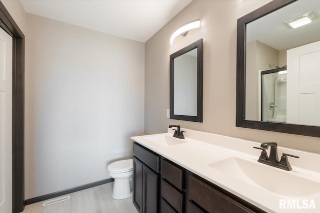 bathroom with a shower with door, a sink, visible vents, and toilet