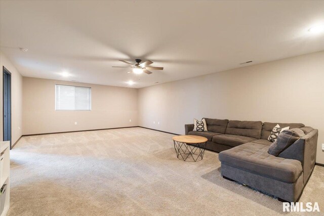 living room featuring visible vents, baseboards, a ceiling fan, and light colored carpet