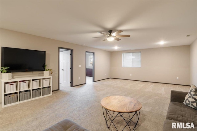 carpeted living room featuring baseboards and a ceiling fan