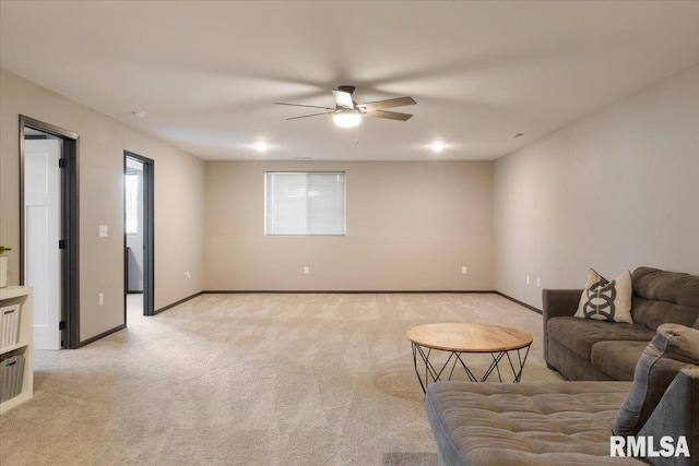 living room featuring light carpet, baseboards, and a ceiling fan