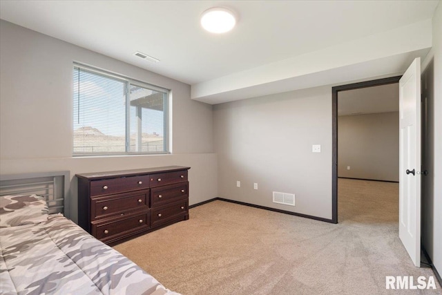 bedroom with visible vents, baseboards, and light carpet