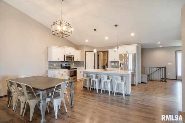 dining area featuring baseboards, recessed lighting, wood finished floors, and lofted ceiling