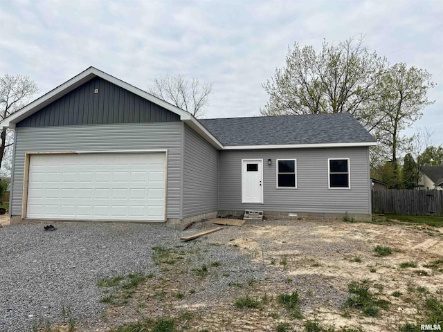 ranch-style home featuring roof with shingles, gravel driveway, entry steps, a garage, and fence