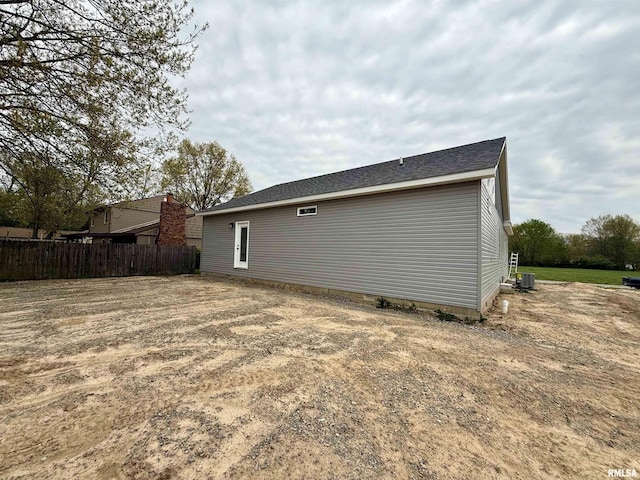 back of house featuring central AC unit and fence