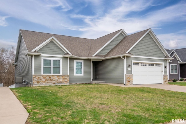 craftsman-style home featuring an attached garage, concrete driveway, stone siding, and a front lawn