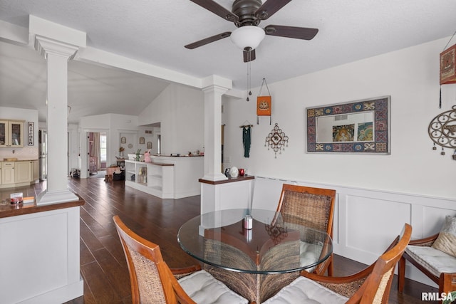 dining area featuring wood-type flooring, ceiling fan, ornate columns, and vaulted ceiling