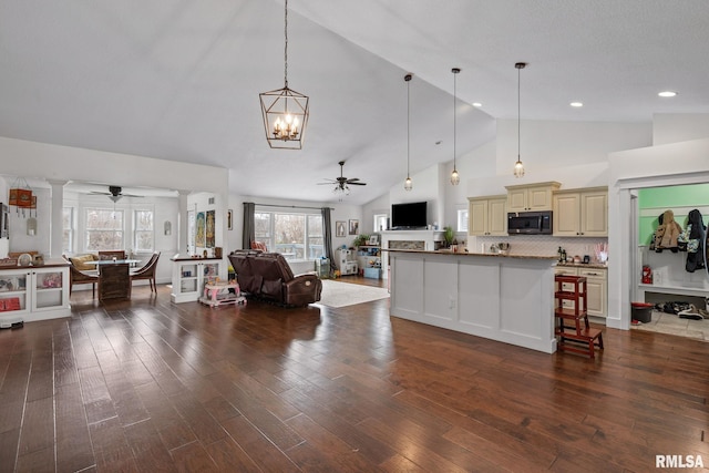 living room with dark wood finished floors and ceiling fan with notable chandelier