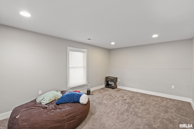 unfurnished room with visible vents, baseboards, a wood stove, carpet floors, and recessed lighting