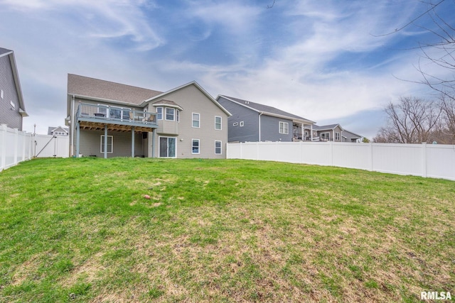 back of house featuring a fenced backyard and a lawn