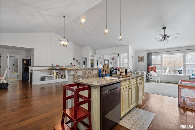 kitchen with stainless steel dishwasher, vaulted ceiling, cream cabinetry, dark wood-style flooring, and a sink
