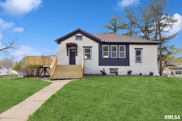 bungalow with a front yard, roof with shingles, and a wooden deck