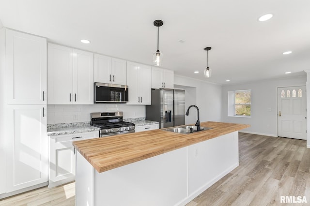 kitchen featuring backsplash, a sink, white cabinetry, and stainless steel appliances