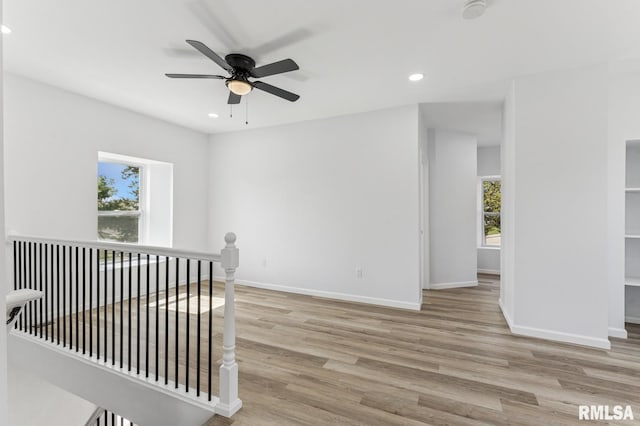 empty room featuring wood finished floors, ceiling fan, baseboards, and recessed lighting
