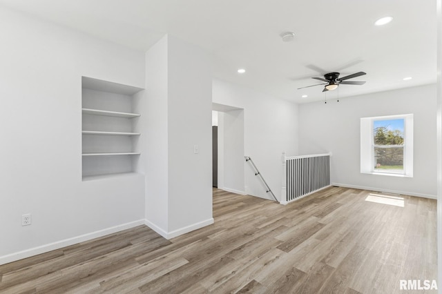 empty room with recessed lighting, light wood-style flooring, and baseboards